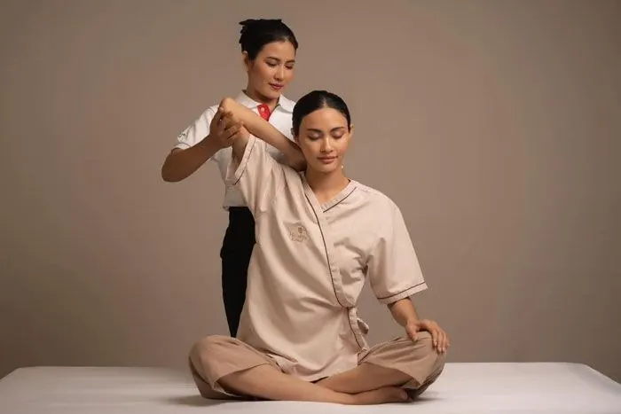 Therapist giving a seated shoulder and back stretch at Sanio's Spa